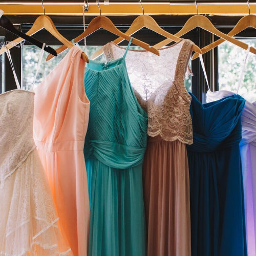 Arrow with lettering 'beach' hangs over the pastel dresses