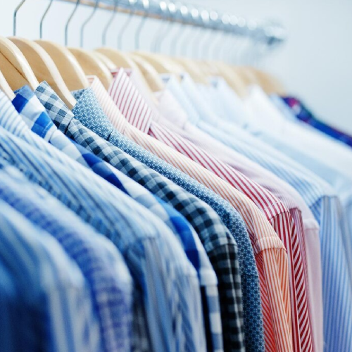 Closeup photo of fashionable clothes on hangers in the shop